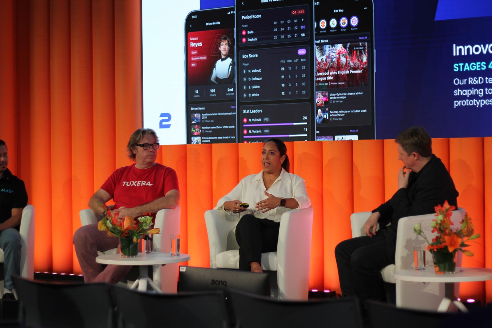 Romy Suárez speaking on the Content Everywhere panel at IBC 2026, seated between panellists from MASV and Tuxera, with Arena app screens on the presentation display behind them.
