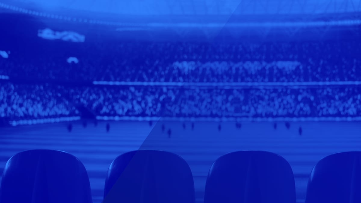 Un fan qui consulte son téléphone avant un événement sportif en direct, anticipation pré-événement dans les apps sportives